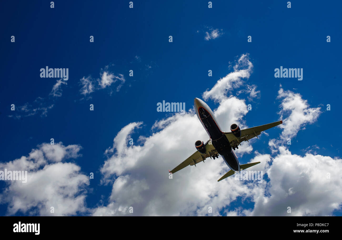 The plane on a background of blue sky and white clouds Stock Photo - Alamy