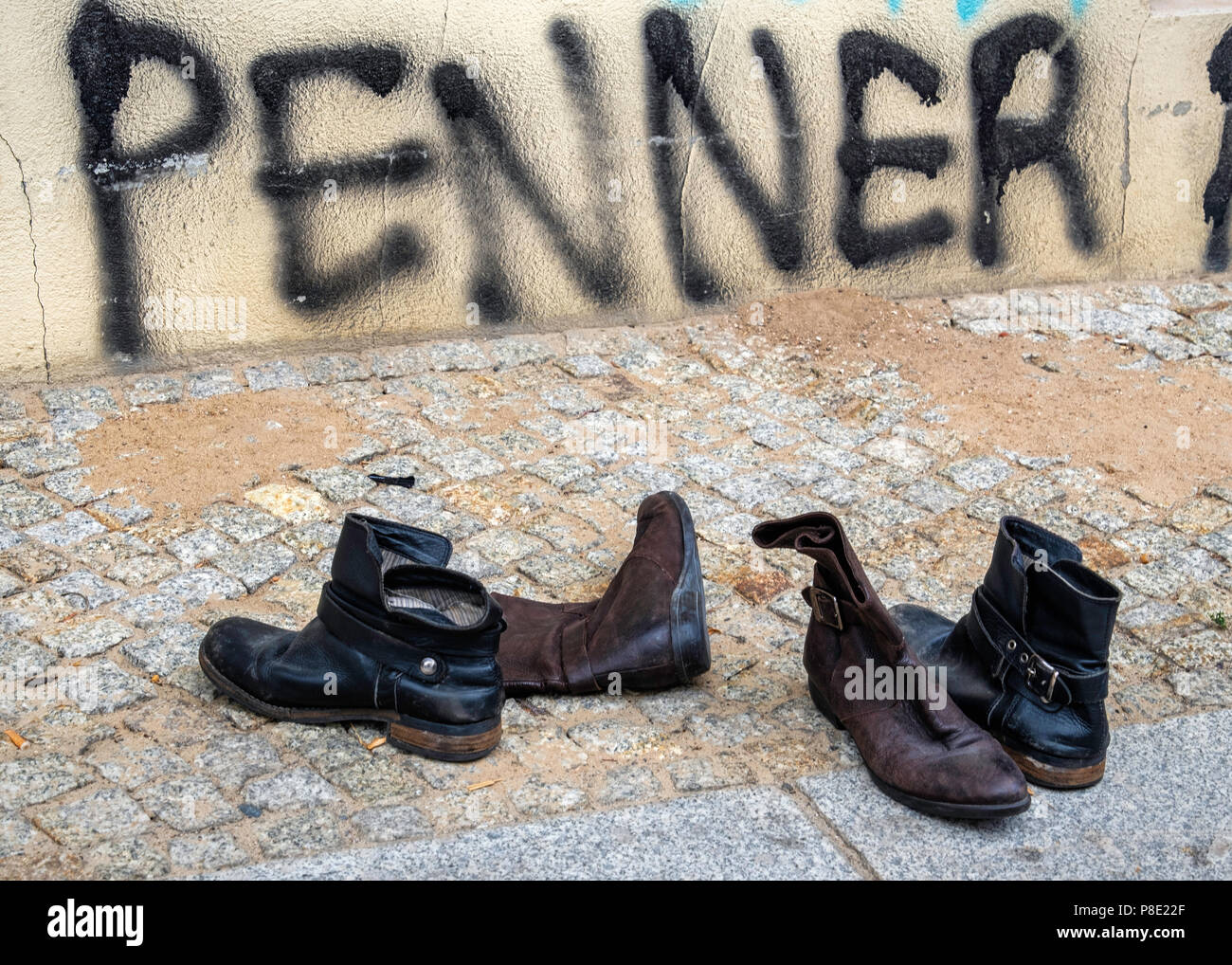 Berlin,Mitte. Urban Still life. Discarded, second hand, used boots on a city pavement with graffiti Stock Photo