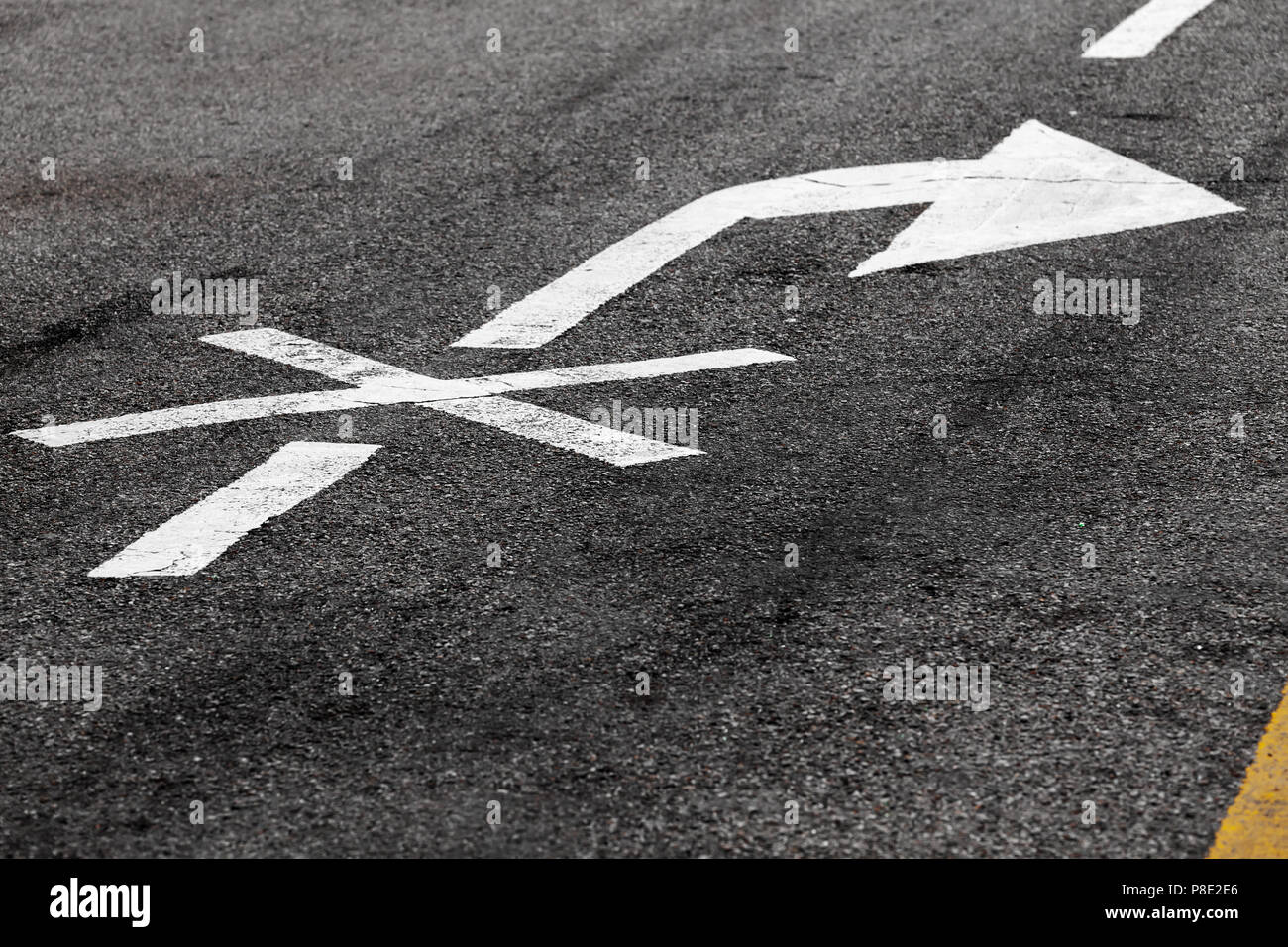 Right turn is prohibited. Crossed white arrow, road marking on dark asphalt. Close-up photo with selective focus Stock Photo