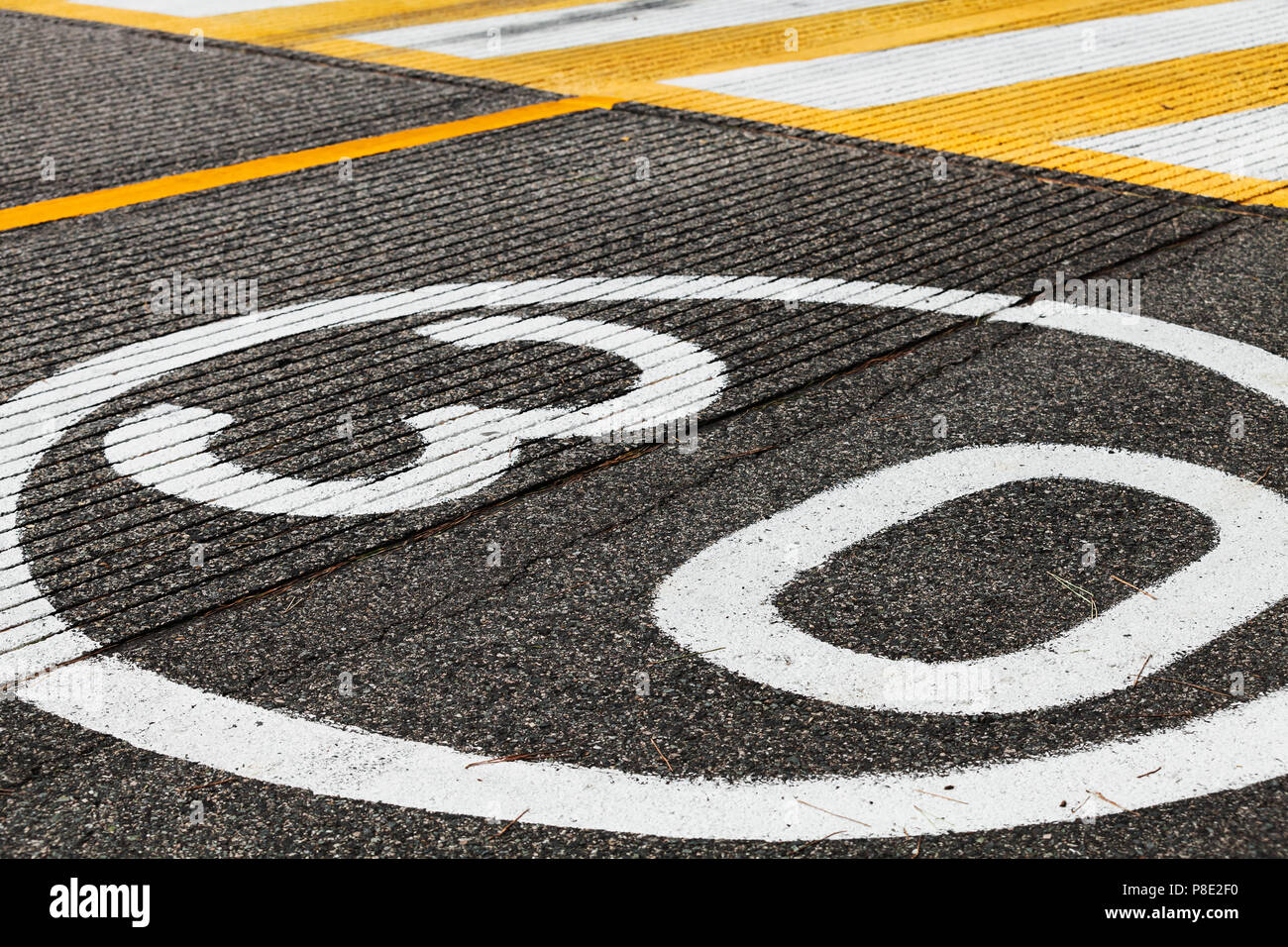 Speed limit road marking before pedestrian crossing on dark gray asphalt Stock Photo