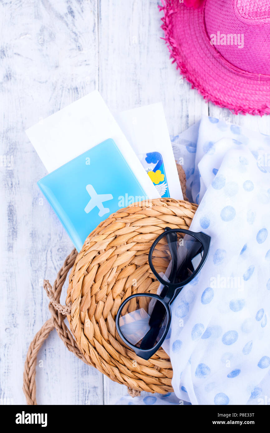 Straw bag, hat, sunglasses and passport for a vacation trip. copy space