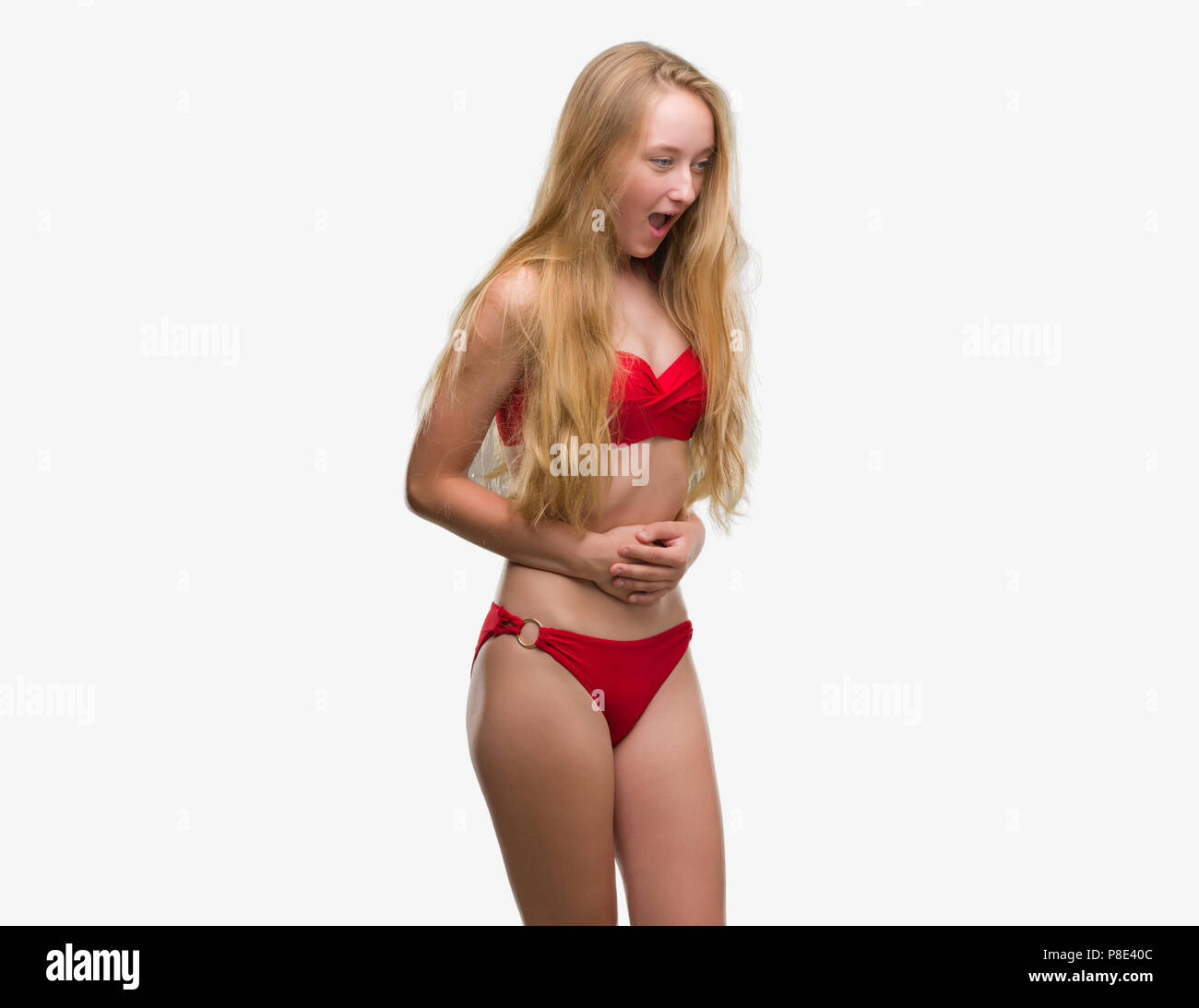 Blonde teenager woman wearing red bikini with hand on stomach because  indigestion, painful illness feeling unwell. Ache concept Stock Photo -  Alamy