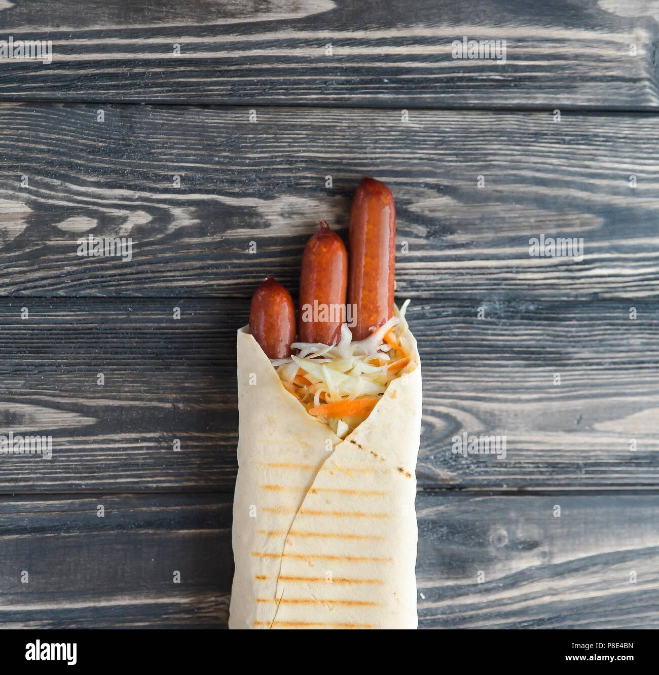 German sausages in pita bread on a dark wooden background.photo with