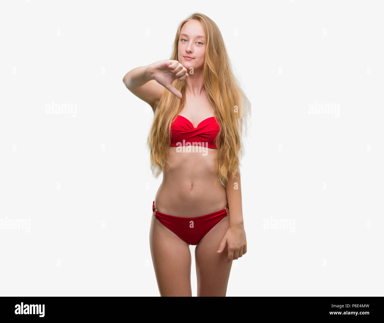 Blonde teenager woman wearing red bikini looking unhappy and angry showing  rejection and negative with thumbs down gesture. Bad expression Stock Photo  - Alamy