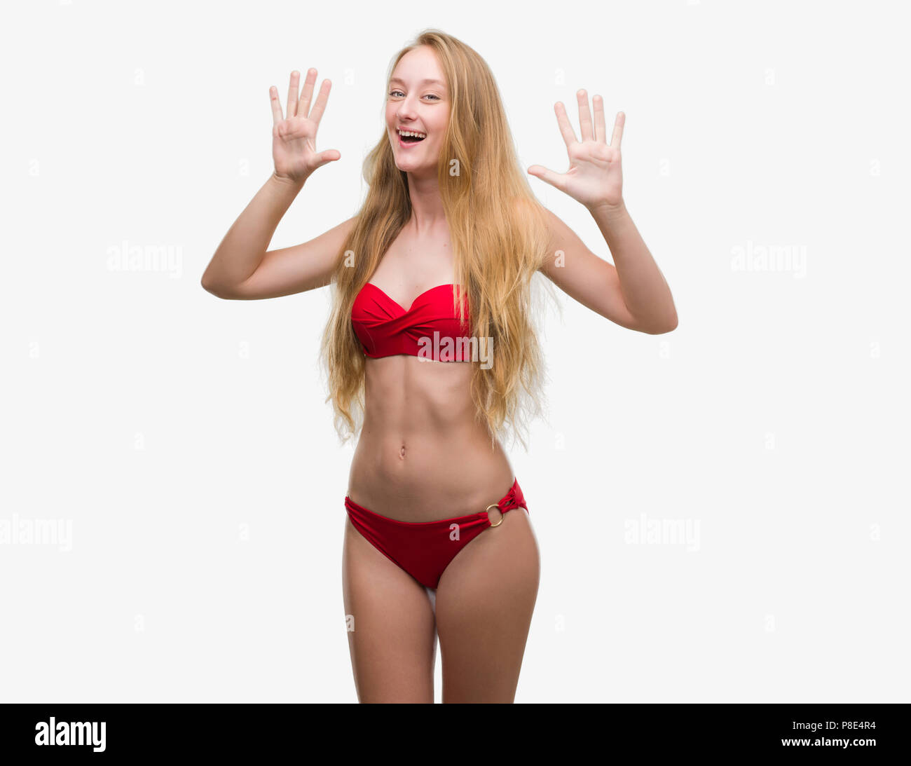 Blonde teenager woman wearing red bikini showing and pointing up with  fingers number ten while smiling confident and happy Stock Photo - Alamy