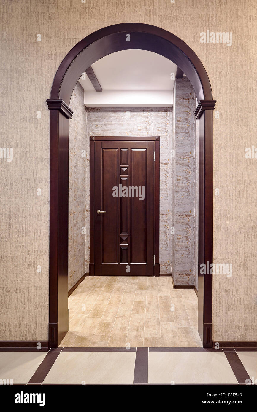 Passage Through Wooden Archway Into Corridor With Entrance Door