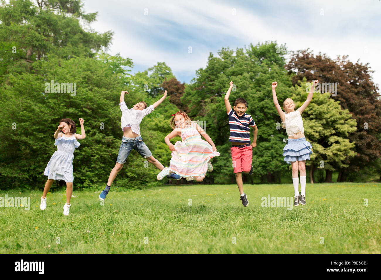 Group of five happy children jumping outdoors., Group of fi…