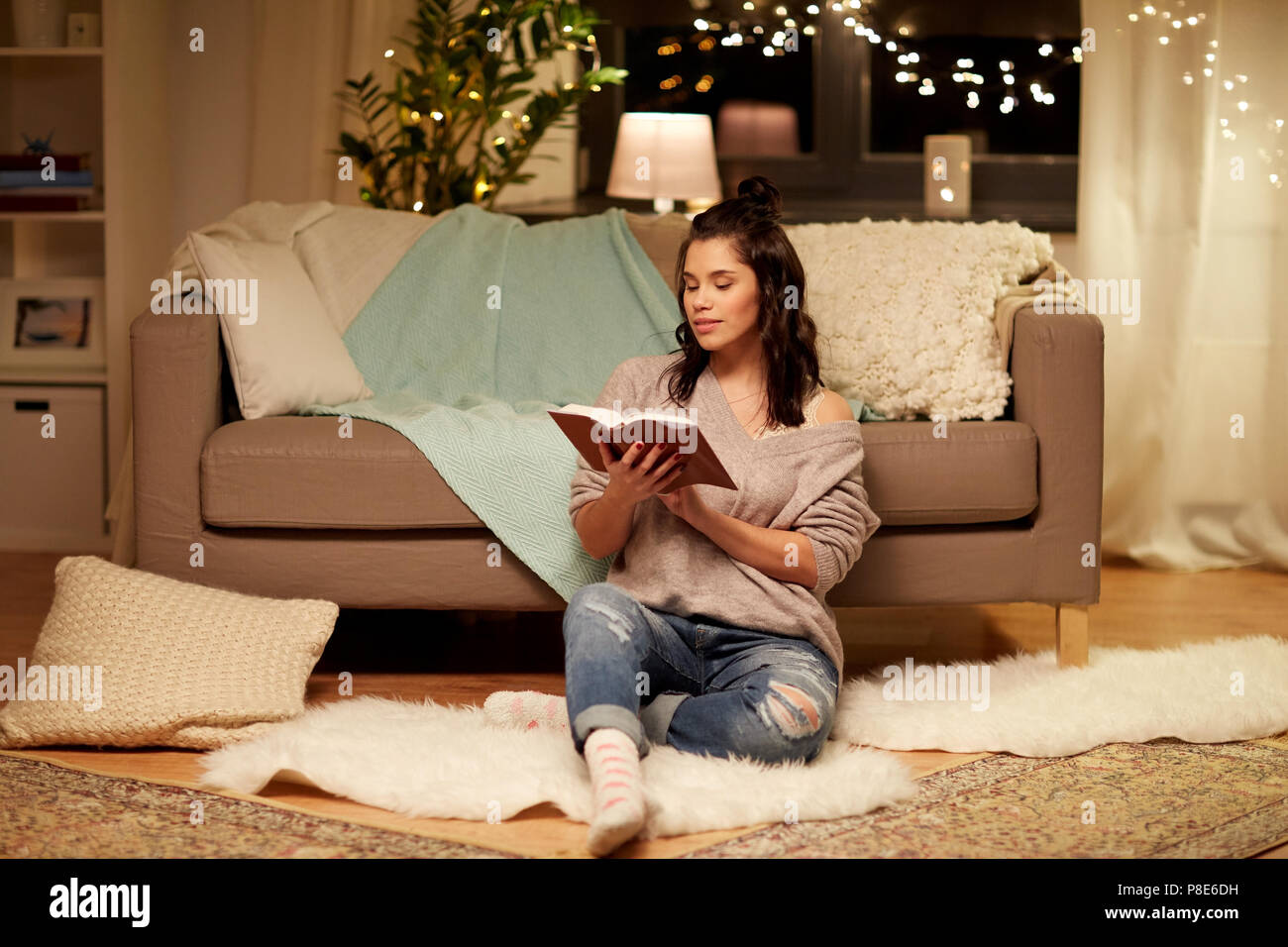 happy young woman reading book at home Stock Photo