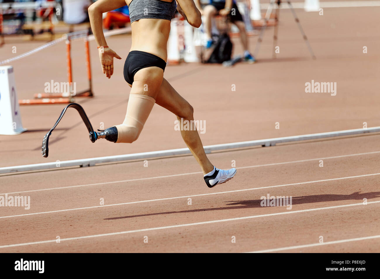 woman runner disabled athlete on prosthesis leg running in track Stock Photo