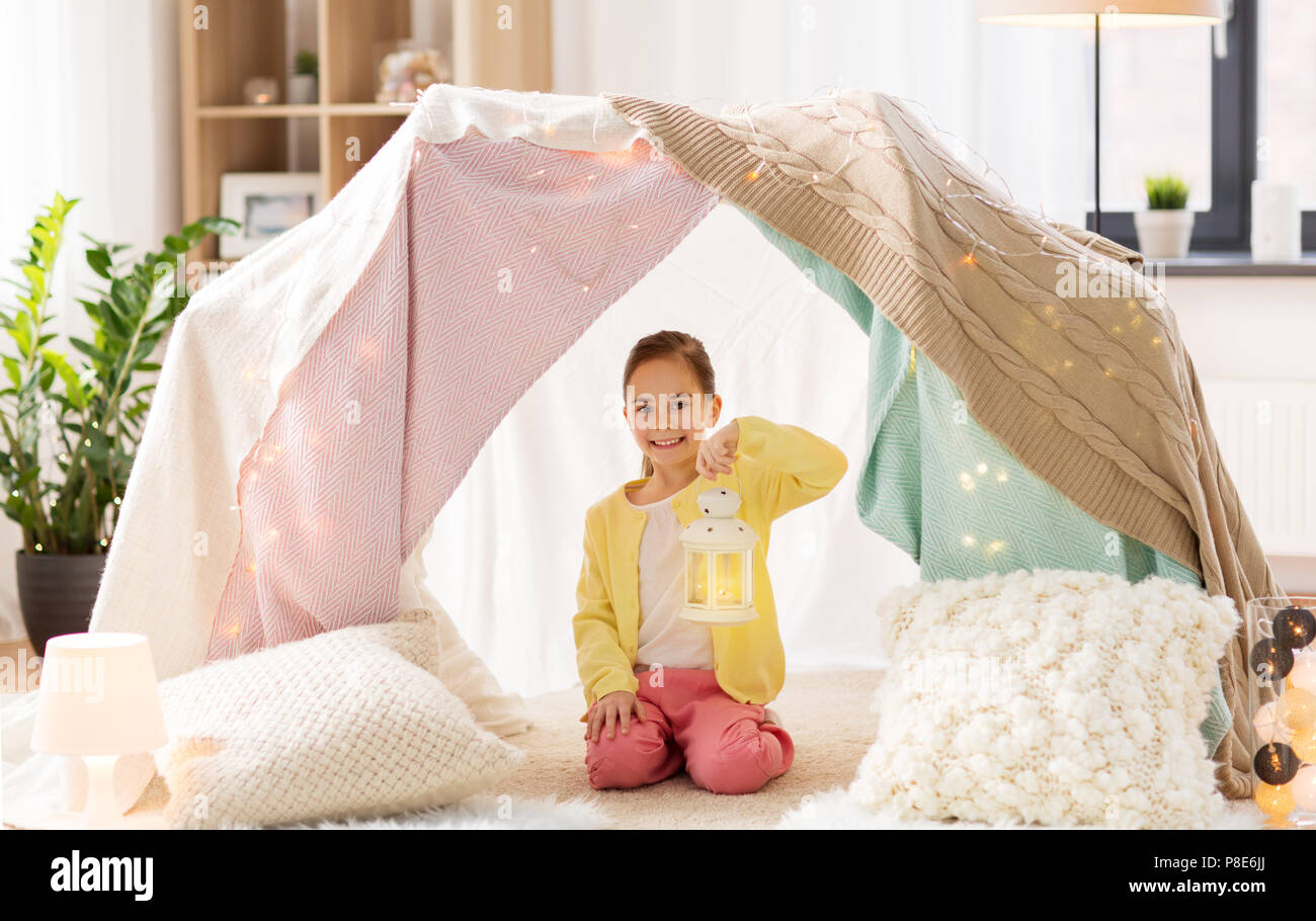 little girl with lantern in kids tent at home Stock Photo
