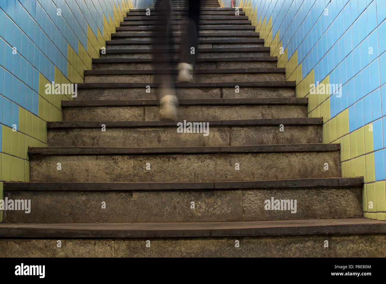 Legs in motion blur running up stairs in subway station. Stock Photo