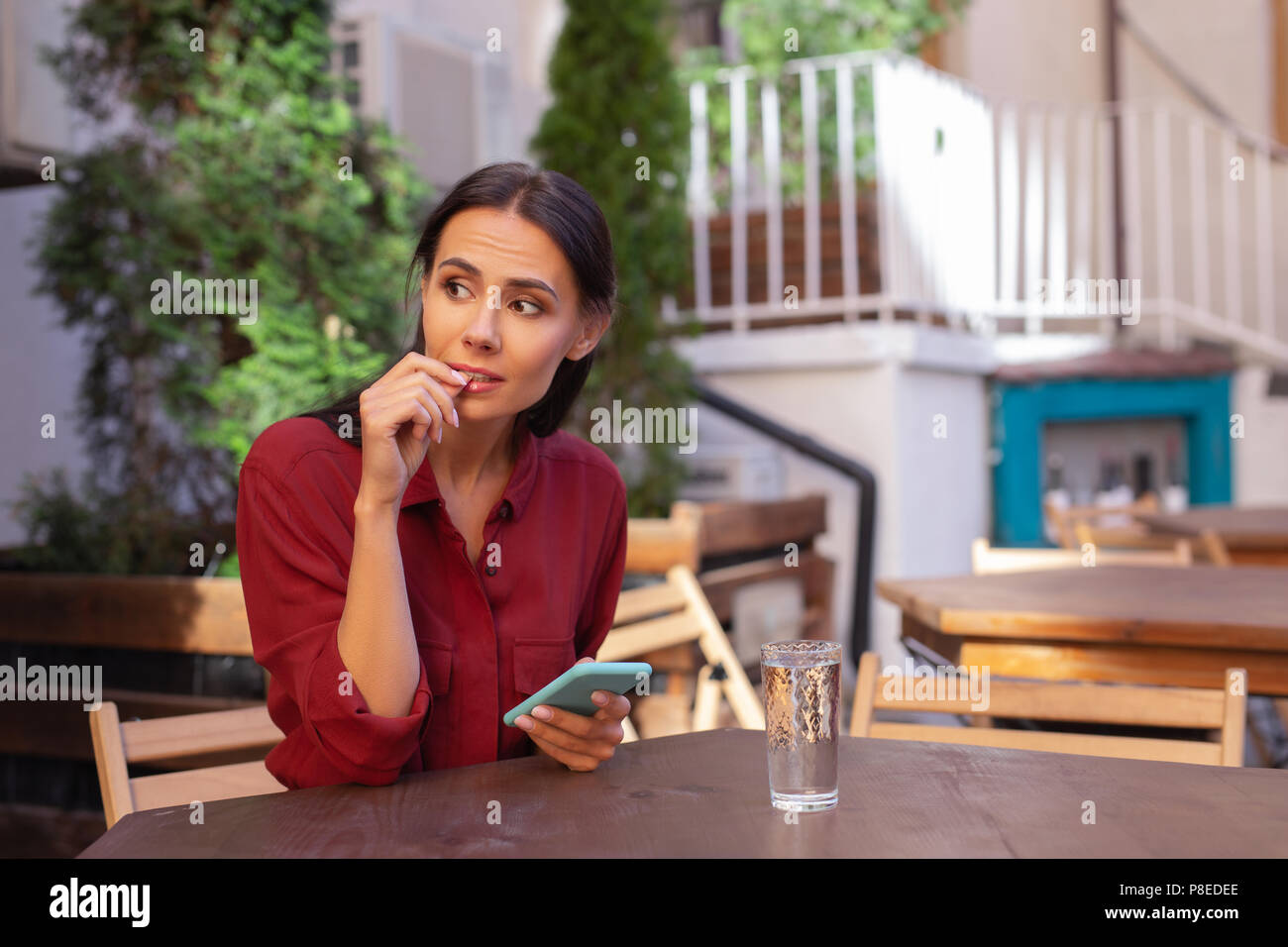 Woman feeling bored while waiting for her order in cafe Stock Photo