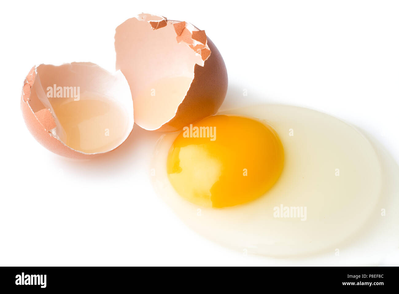 A broken chicken egg lies on a white background with a shell, yo Stock Photo
