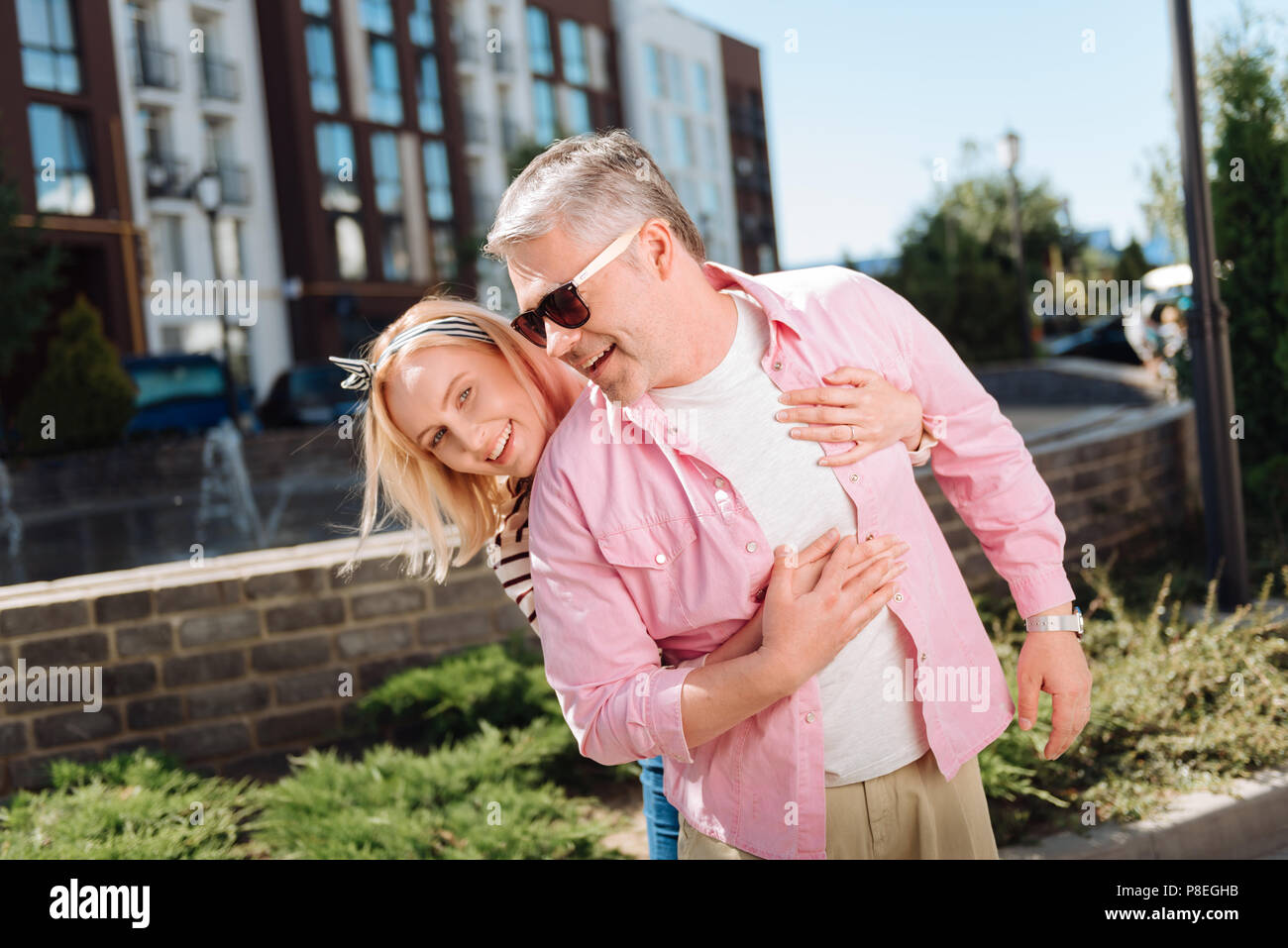 Nice pleasant woman standing behind her husband Stock Photo Alamy