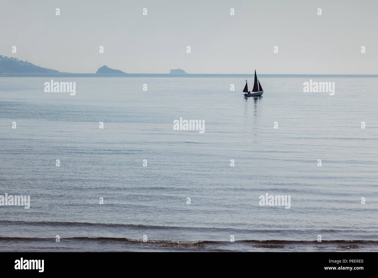 20 May 2018: Paignton, Devon, UK - A sailing boat in Torbay on a soft light day. Stock Photo