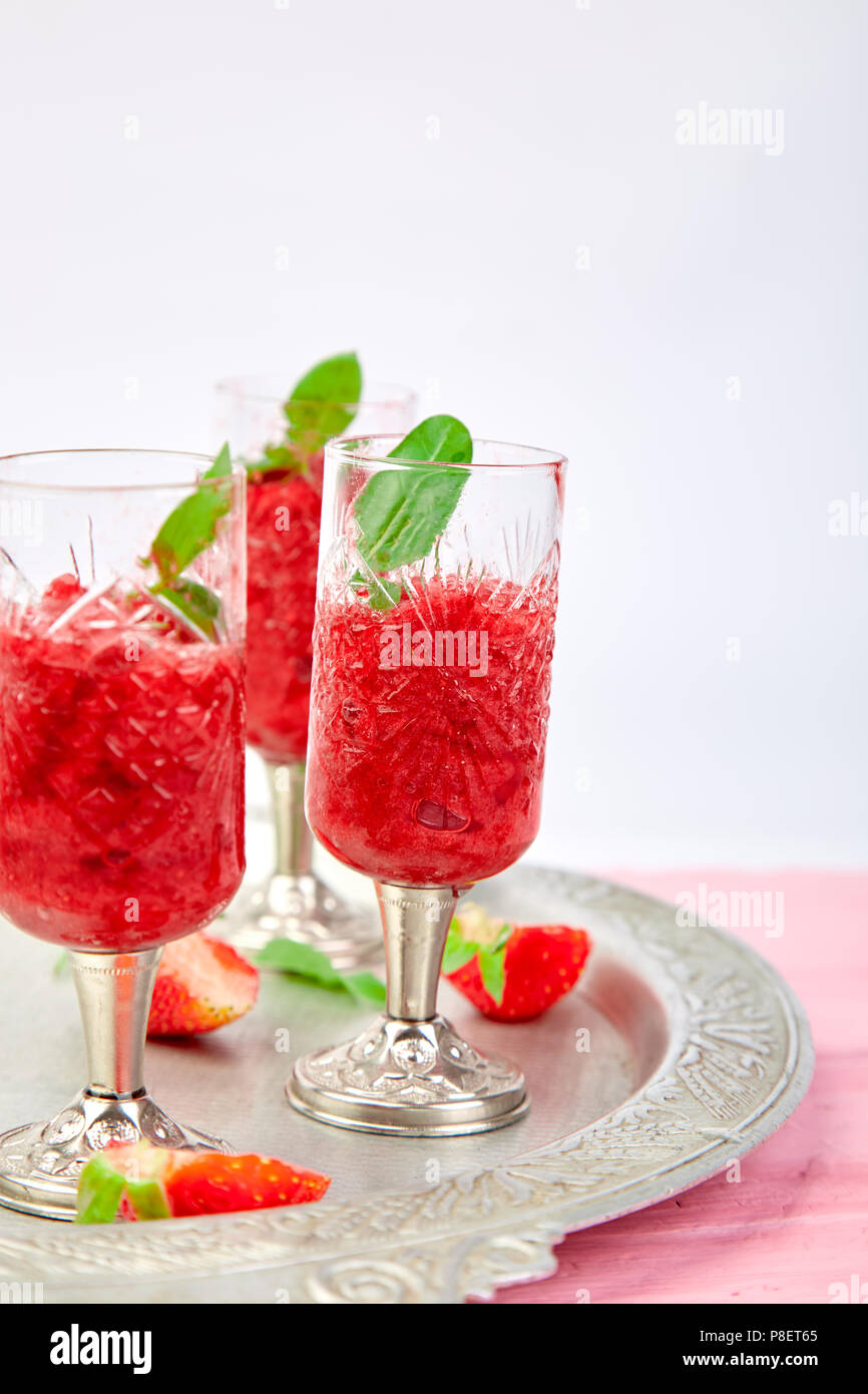 Summer refreshing strawberry sorbet, slush granita drink in serving glasses on silver tray