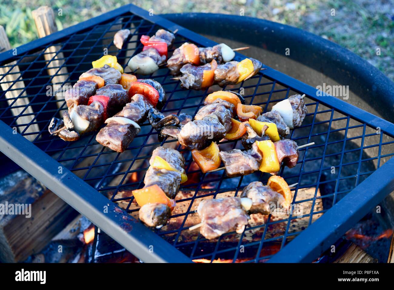 Beef kabobs being cooked over the fire pit Stock Photo