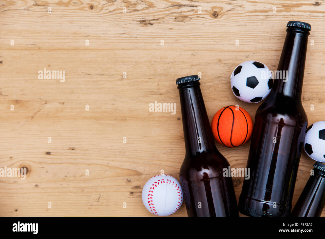 Sports match party. Beer bottle with football, basketball, baseball balls Stock Photo