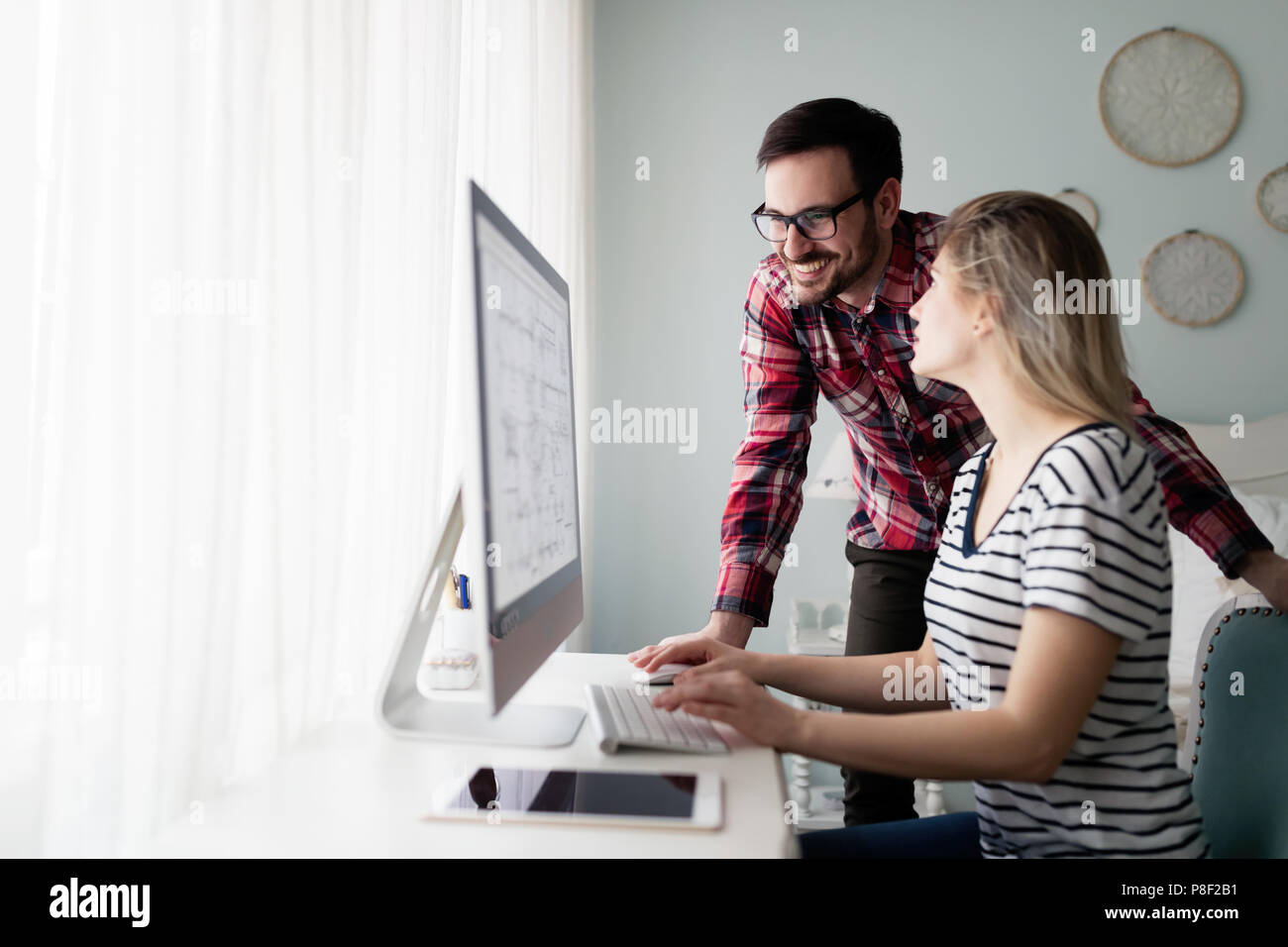 Young couple of designers working on computer Stock Photo