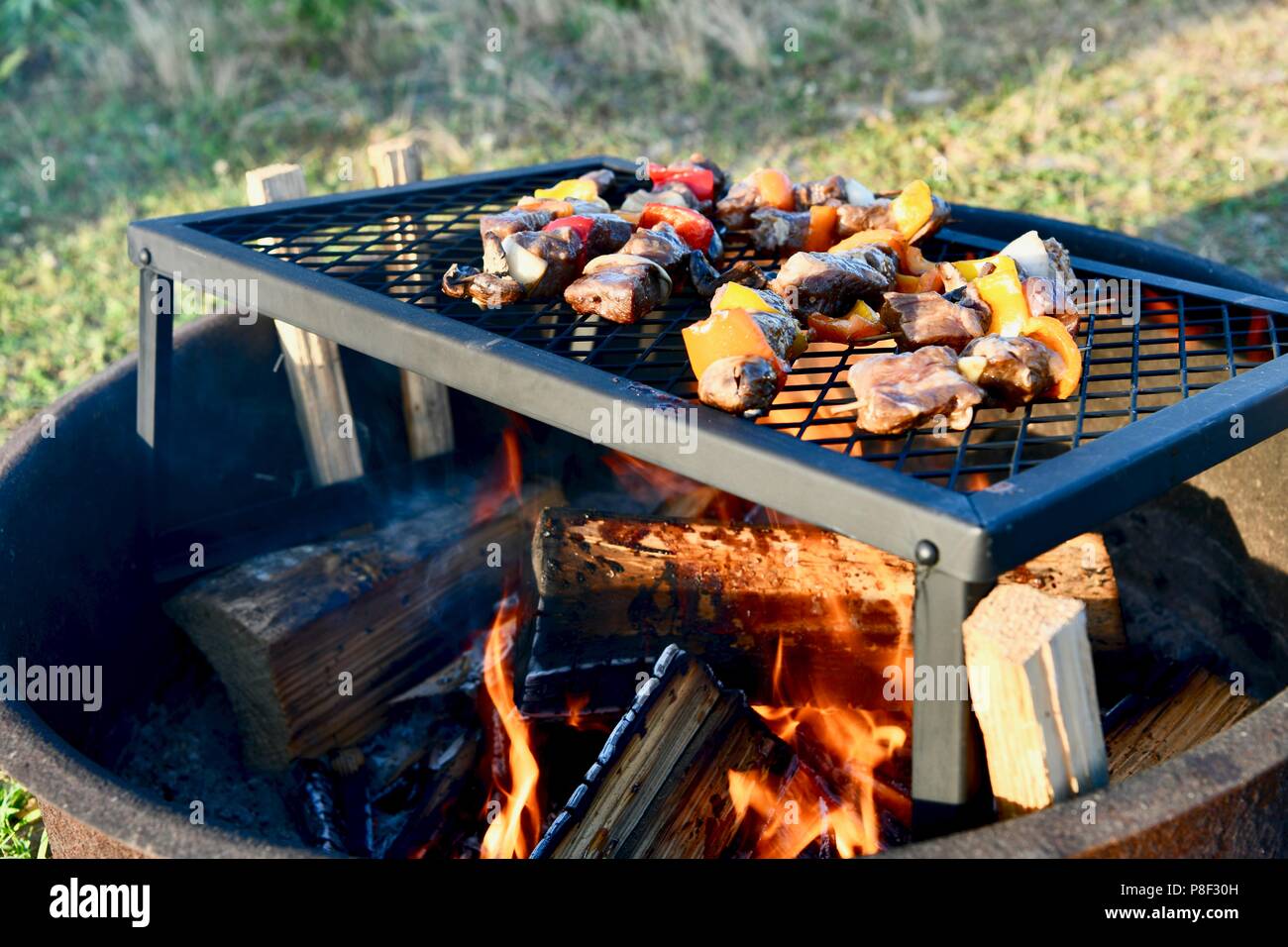 Beef kabobs being cooked over the fire pit Stock Photo