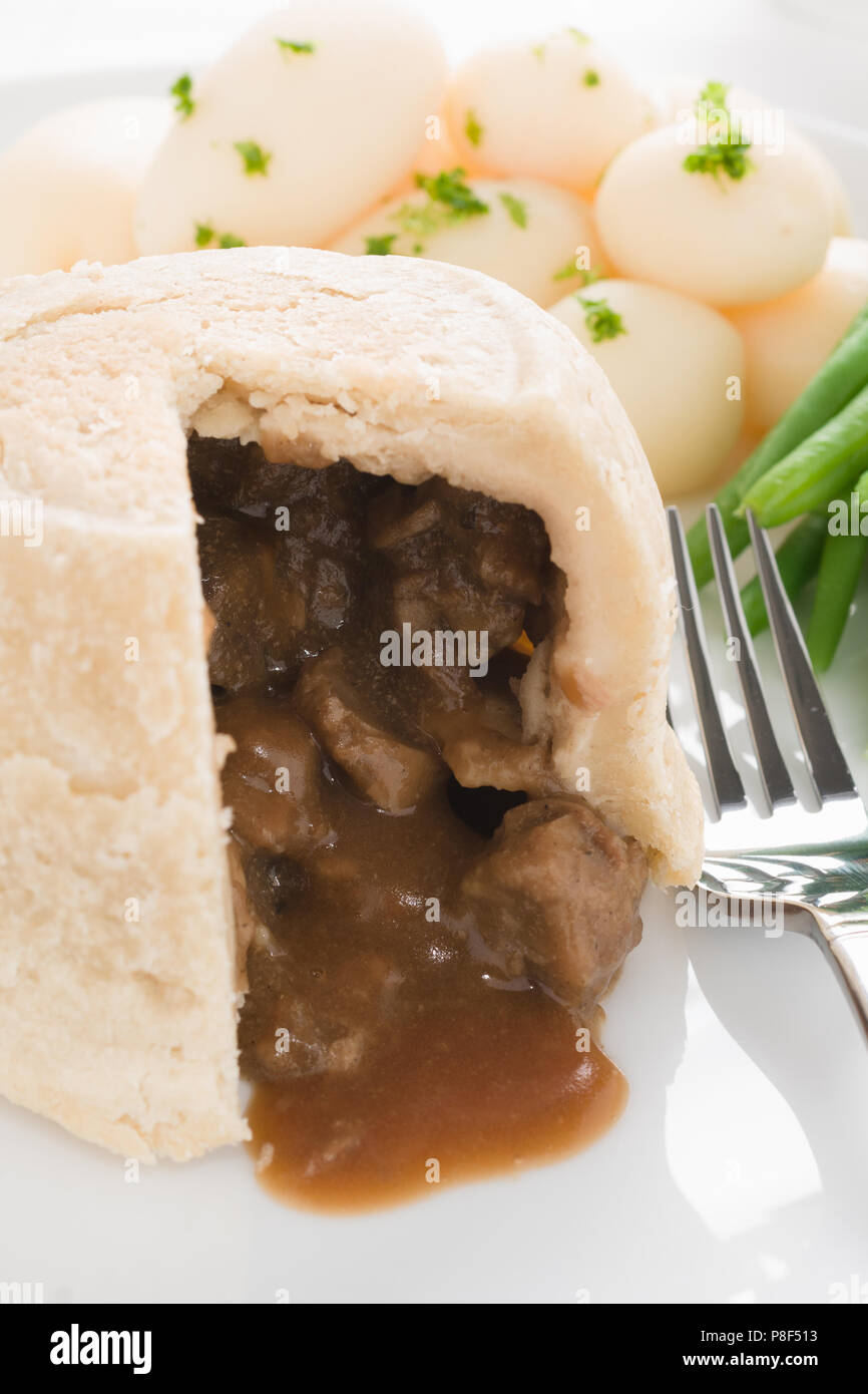 Steak and kidney pudding a traditional steamed suet pastry pie originating  from the UK Stock Photo - Alamy