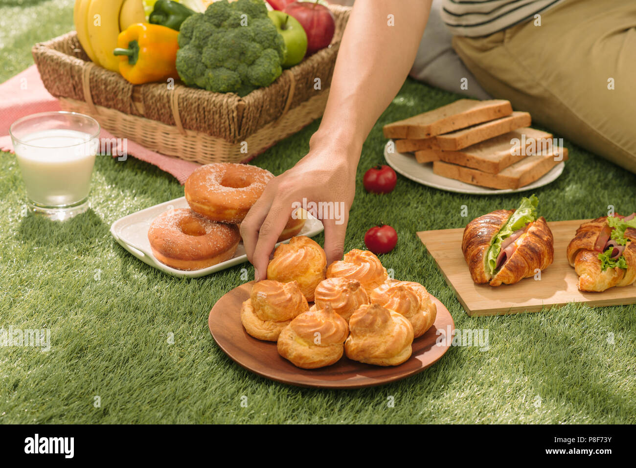 Picnic wicker basket with food, bread, fruit and orange juice on a red ...