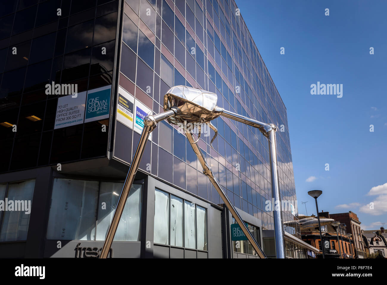 Metallic sculpture in Crown Square of a Martian tripod invader from H G Wells' classic novel War of the Worlds, which is set in Woking, Surrey, UK Stock Photo