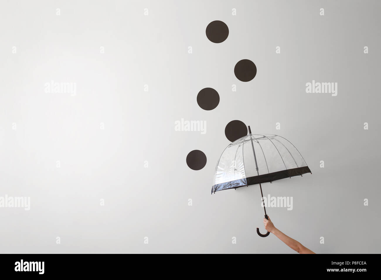 Conceptual woman holding an umbrella in the rain Stock Photo