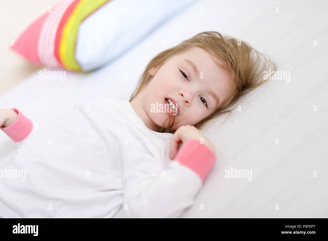 Little preschooler girl in pajamas on sunny morning Stock Photo