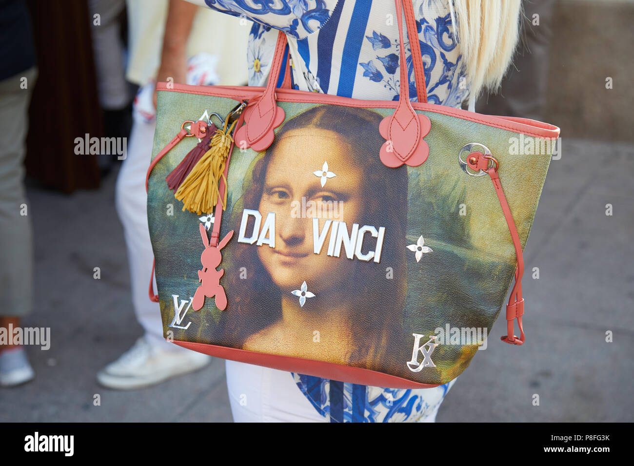 MILAN - JUNE 15: Woman with Da Vinci Louis Vuitton bag with Mona Lisa before Alberta Ferretti fashion show, Milan Fashion Week street style on June 15 Stock Photo