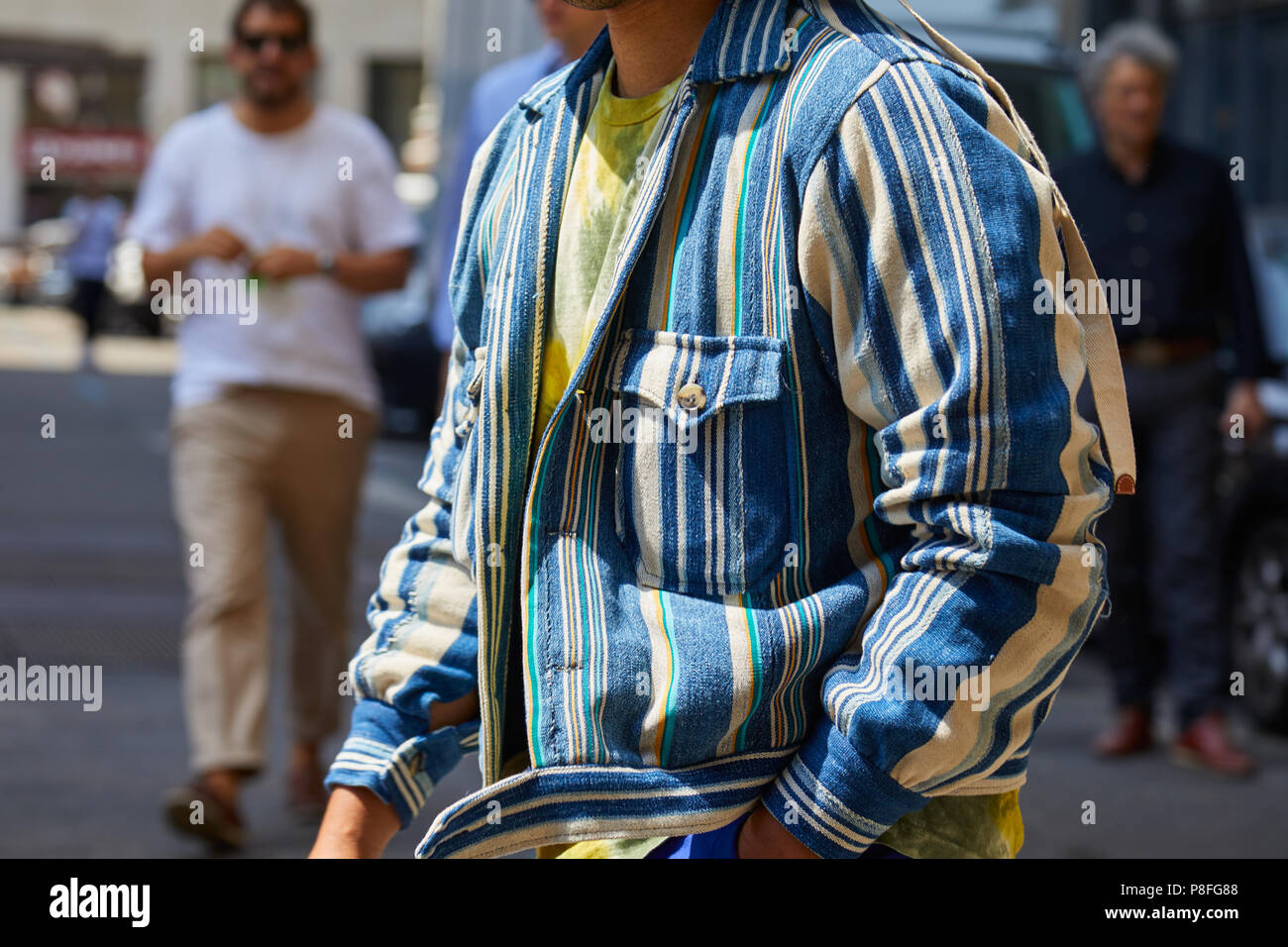 MILAN - JUNE 16: Man with blue and white striped jacket before Marni fashion show, Milan Fashion Week street style on June 16, 2018 in Milan. Stock Photo