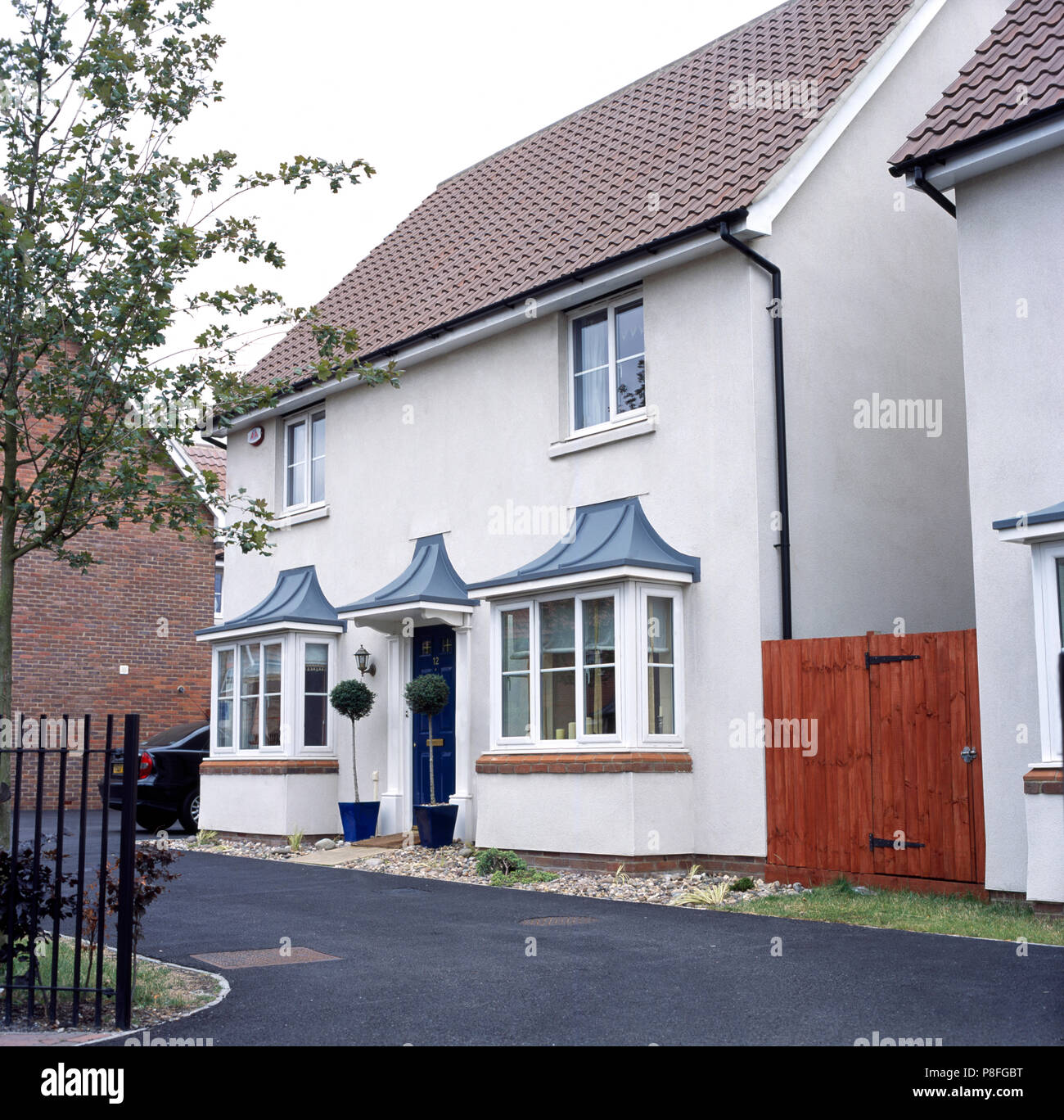 Exterior of a traditional, white painted newbuild house with bay trees