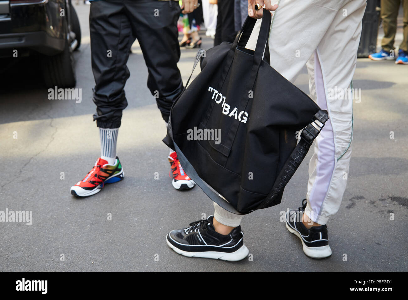 MILAN - JUNE 16: Man with black Off White tote bag and man with red shoes  before Marni fashion show, Milan Fashion Week street style on June 16, 2018  Stock Photo - Alamy
