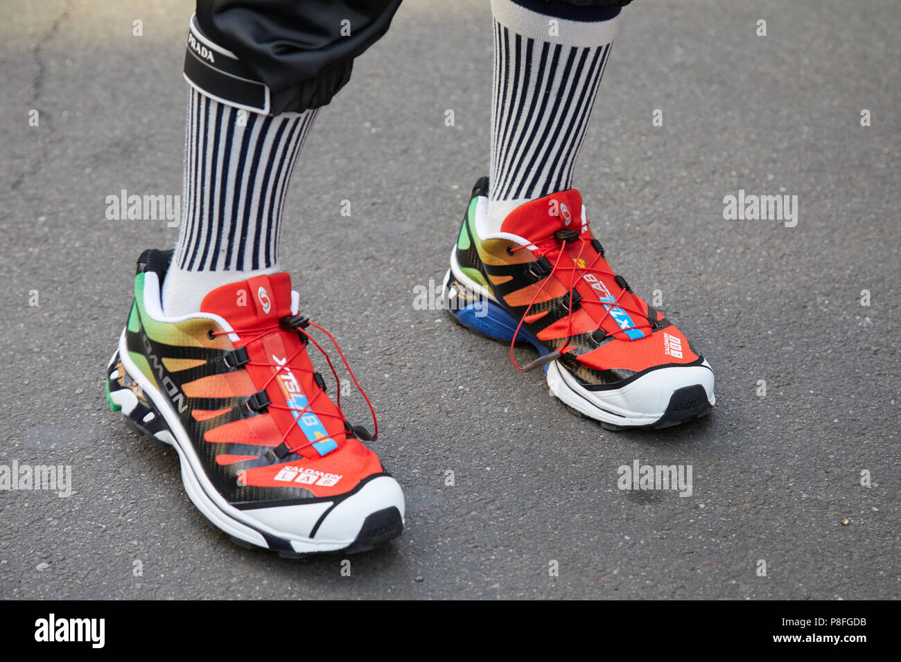 MILAN - JUNE 16: Man with Salomon Lab red, green and white shoes and Prada  trousers before Marni fashion show, Milan Fashion Week street style on June  Stock Photo - Alamy