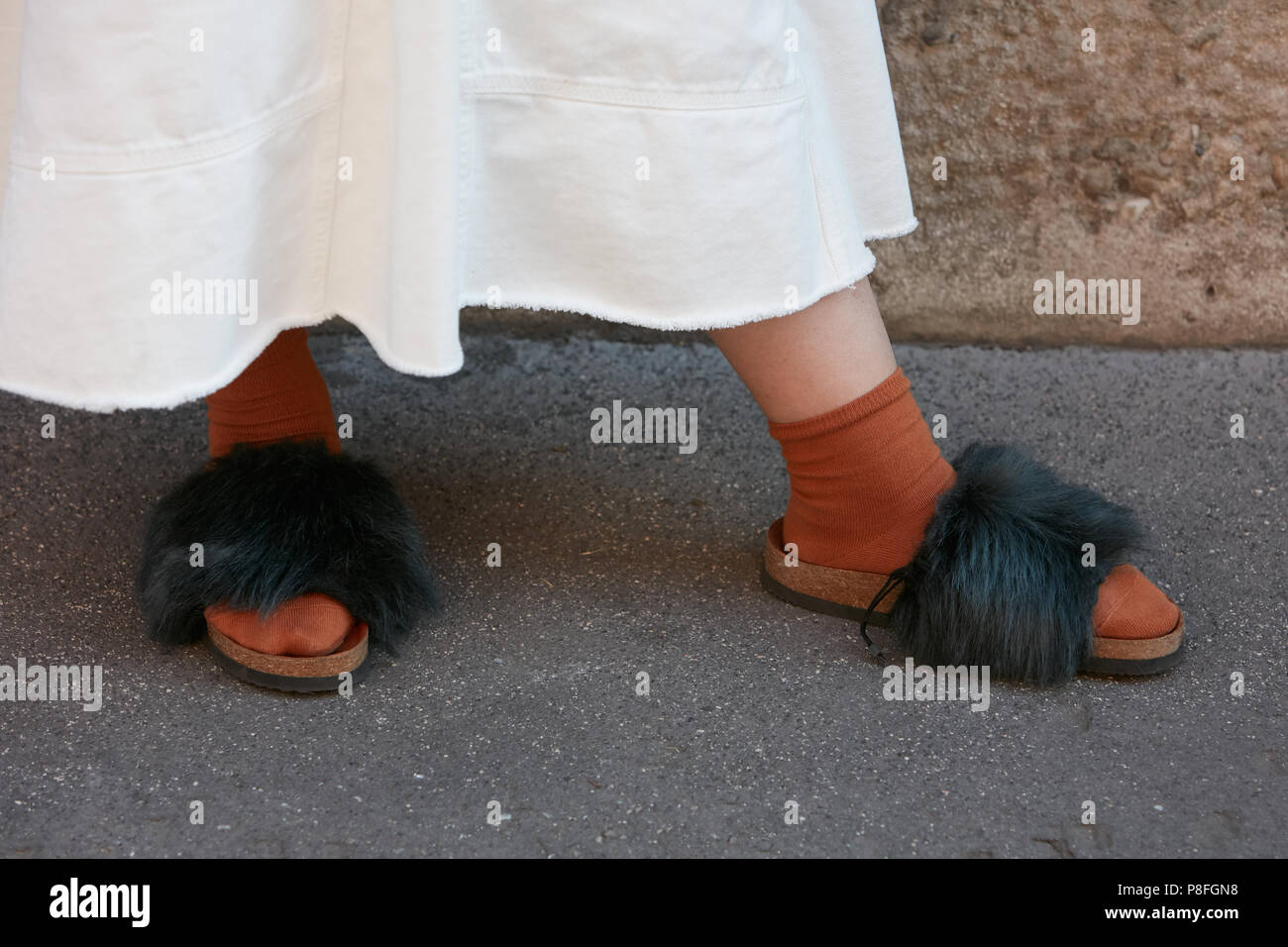 MILAN - JUNE 17: Woman with black fur sleepers with brown socks and white  skirt before Prada fashion show, Milan Fashion Week street style on June 17  Stock Photo - Alamy