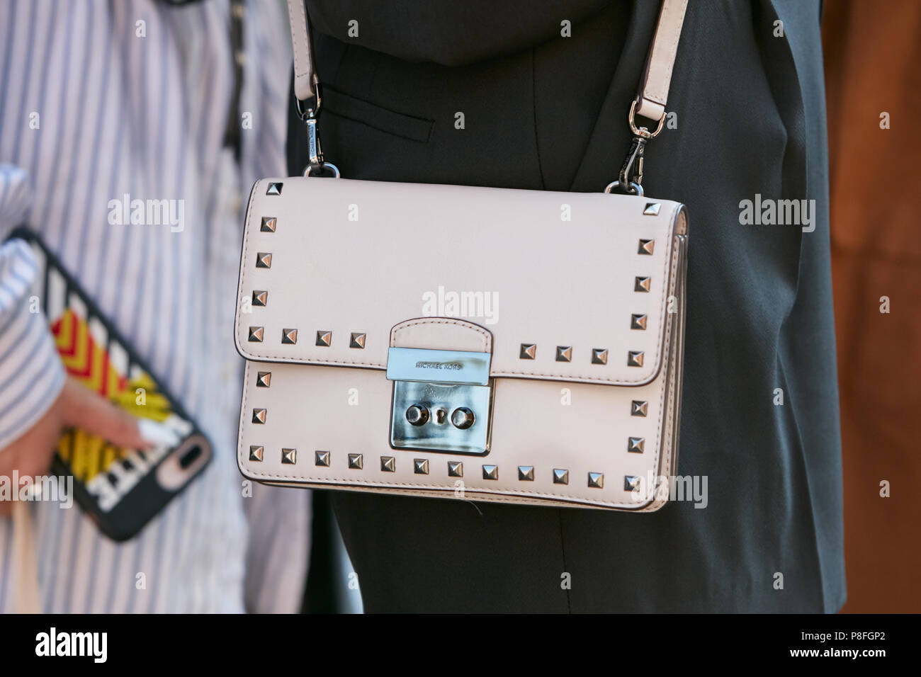 MILAN - JUNE 17: Woman with pale pink Michael Kors leather bag with studs  before Prada fashion show, Milan Fashion Week street style on June 17, 2018  Stock Photo - Alamy