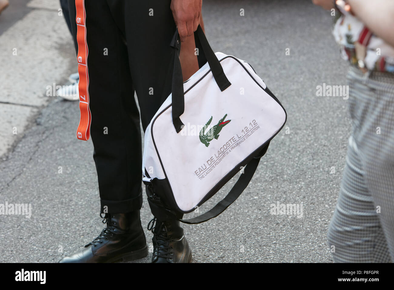 Man with white and black Lacoste bag 