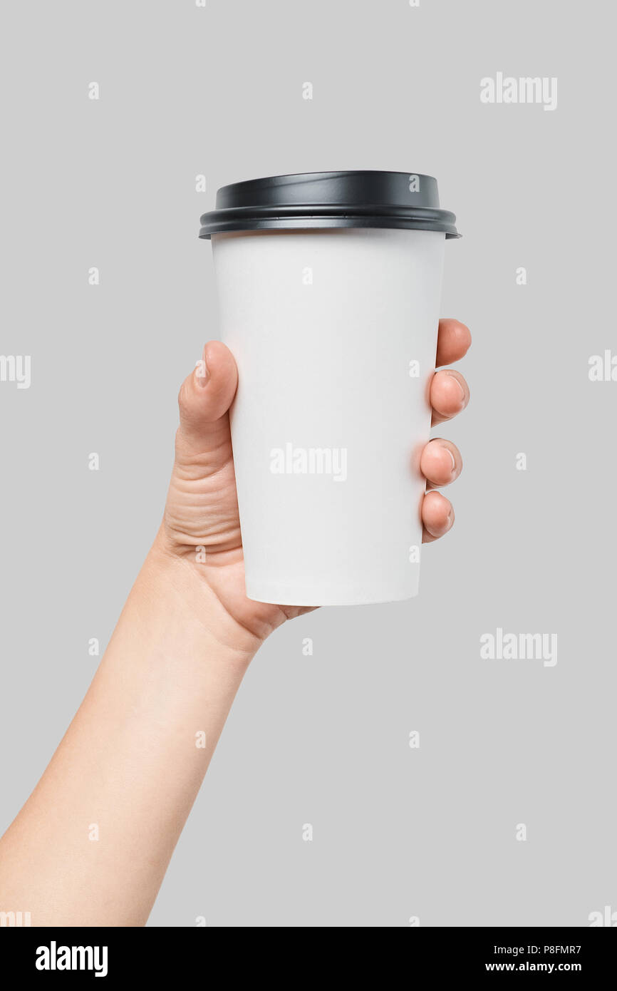 Mockup of women's hand holding white paper large size cup with black cover Stock Photo