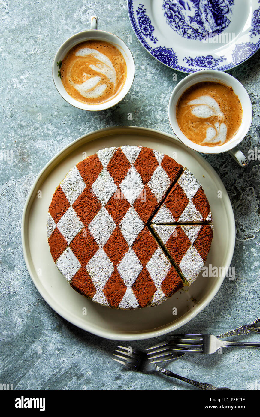 Sponge cake decorated with cocoa powder and icing sugar on a plate ...
