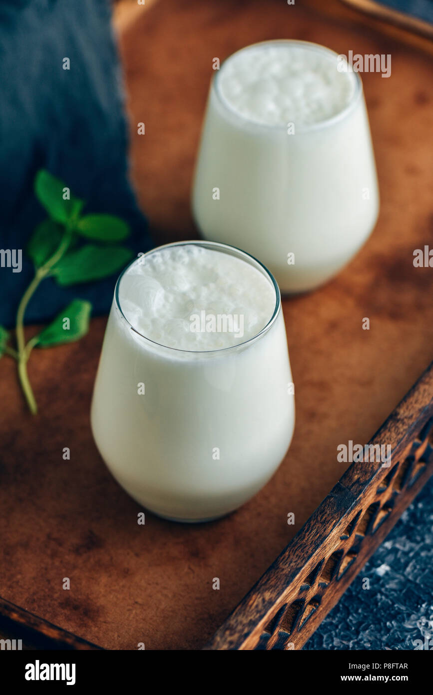 Turkish drink ayran in two glasses photographed in a wooden tray. Stock Photo