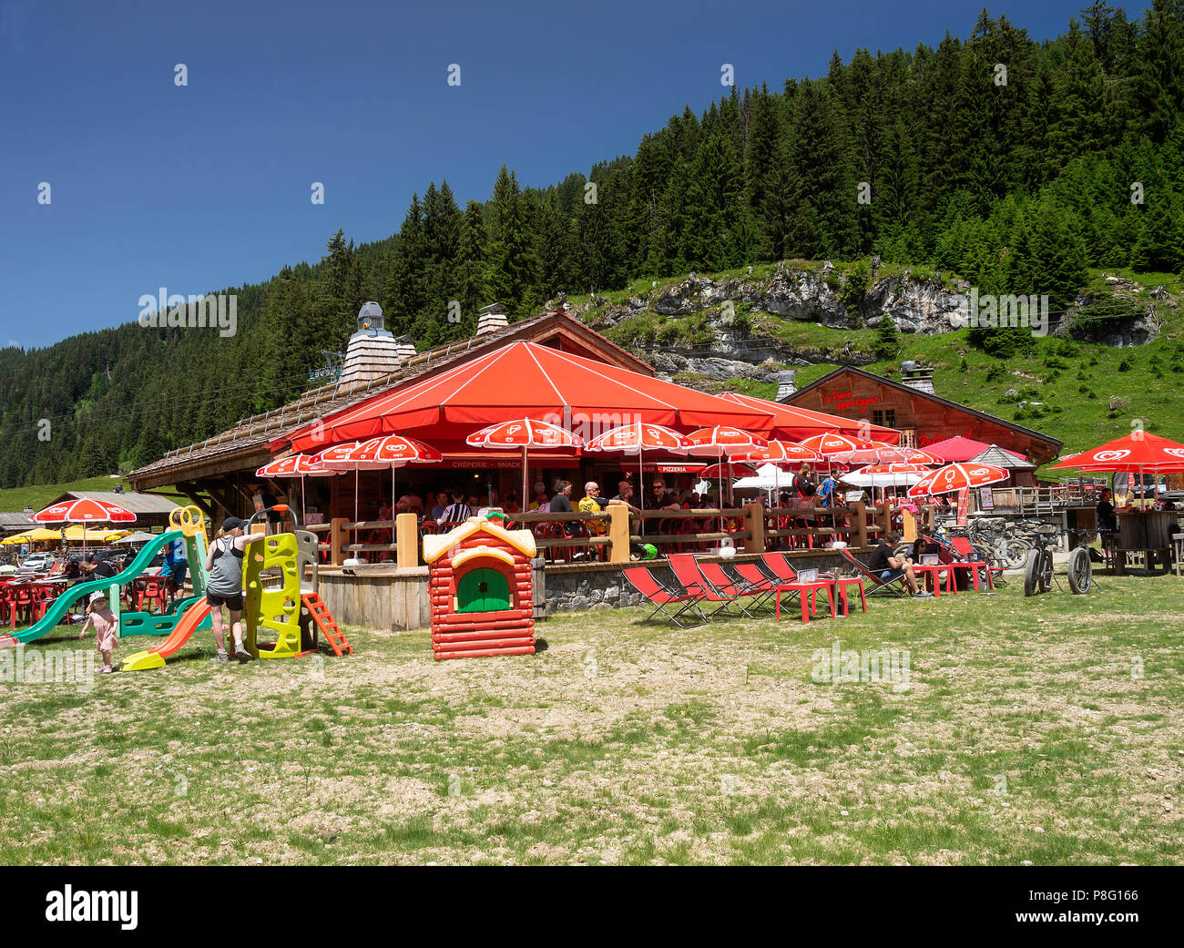 The Beautiful Chalet Style Les Barmettes Restaurant and Bar with Red Umbrellas at Les Lindarets near Montriond Haute-Savoie France Stock Photo