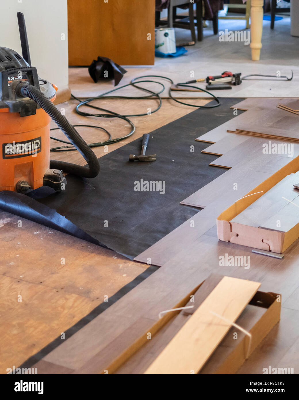 Interior of a home showing tools and where engineered wood floor is being laid during remodeling . USA. Stock Photo