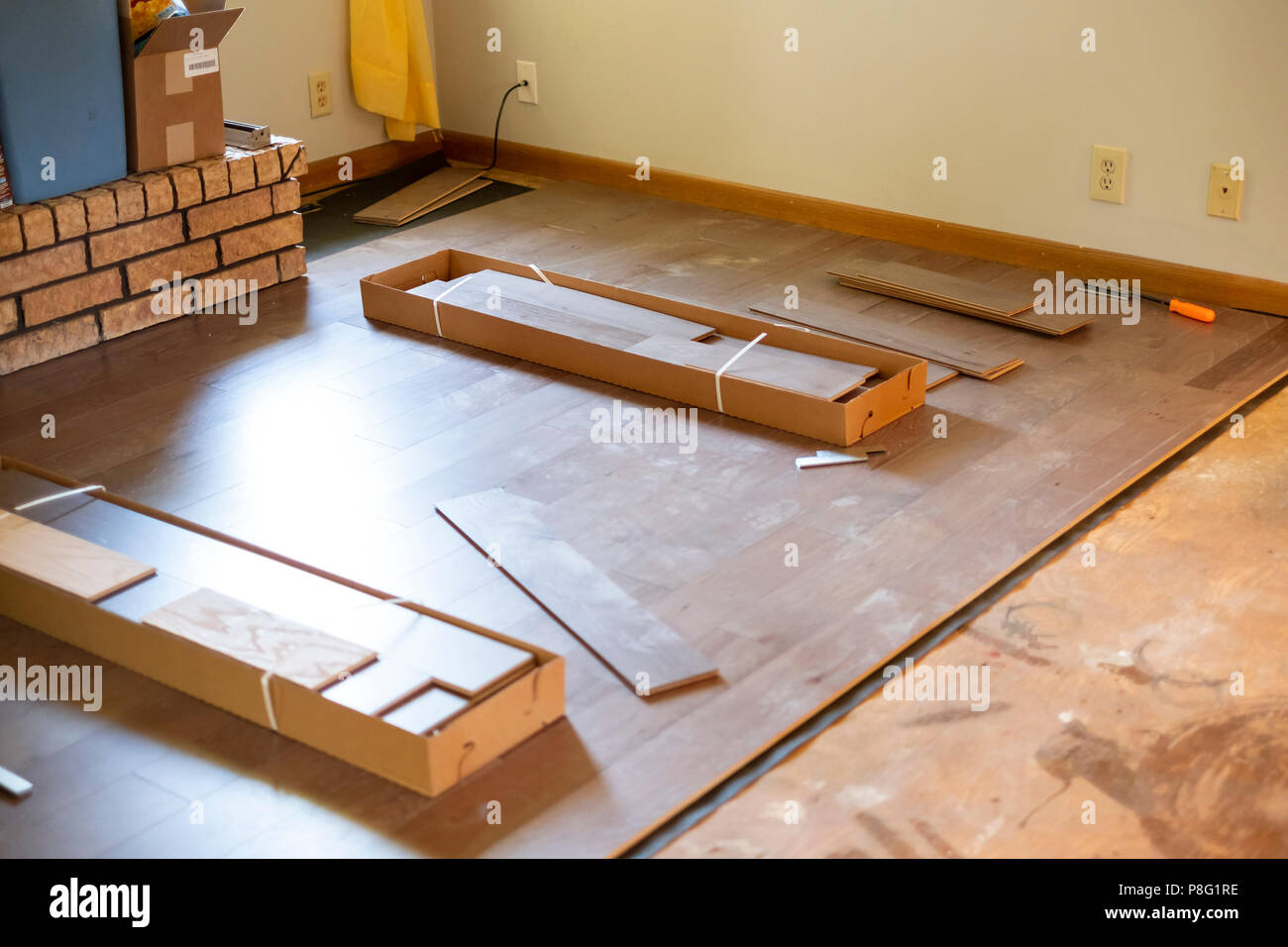 Boxes of engineered wood flooring being installed during s home remodeling project. USA. Stock Photo