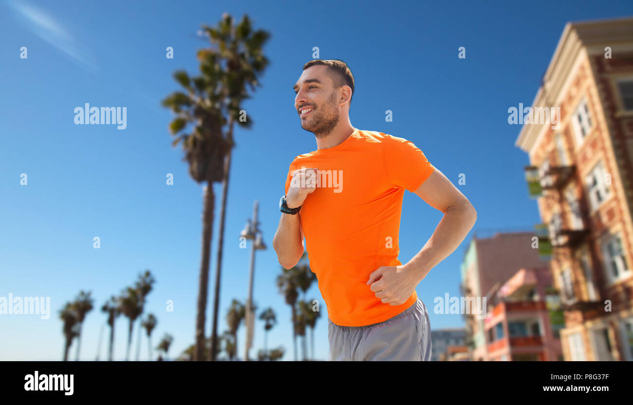 smiling young man running at summer seaside Stock Photo - Alamy