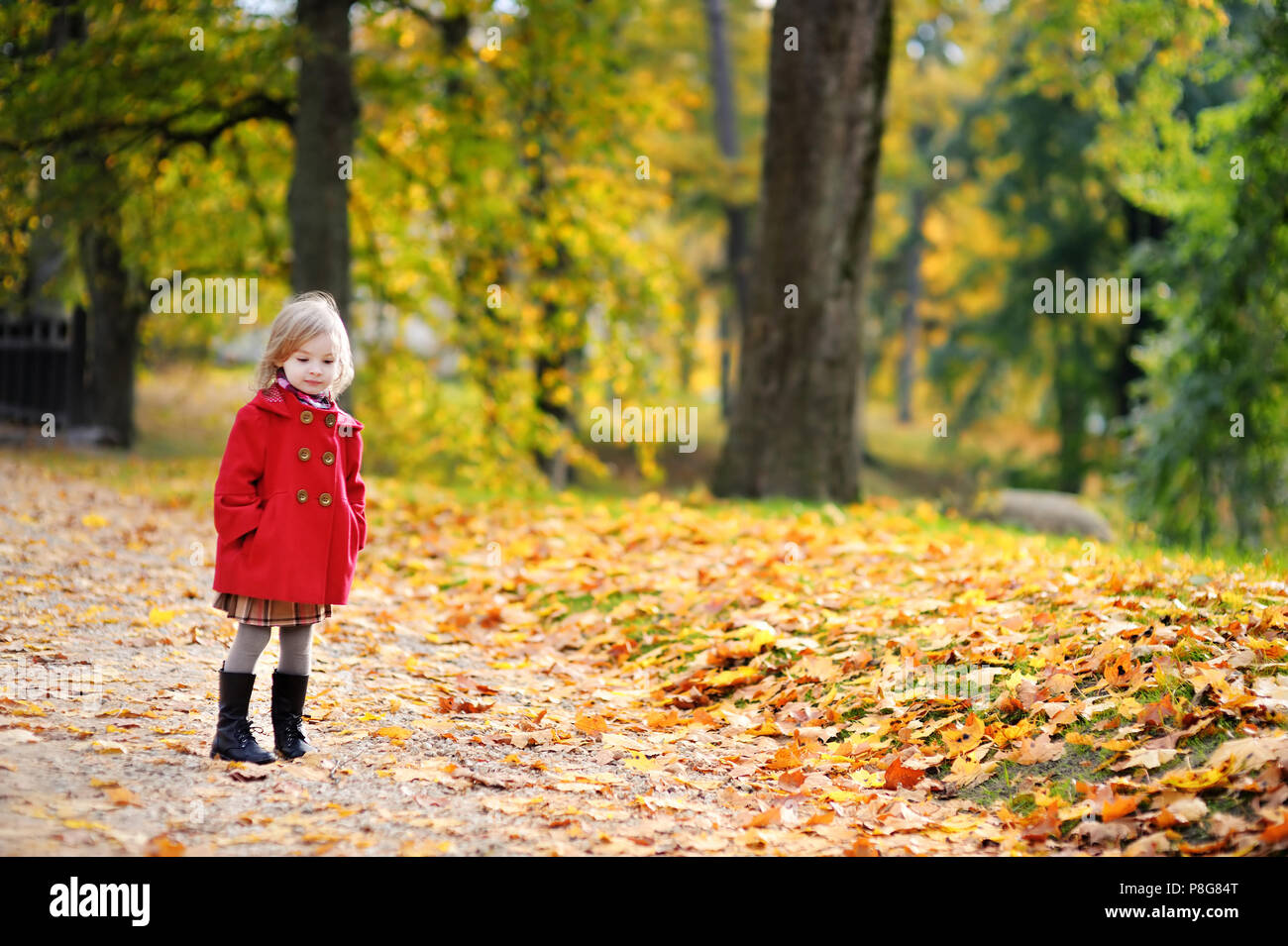 Little girl in a red coat at autumn Stock Photo - Alamy