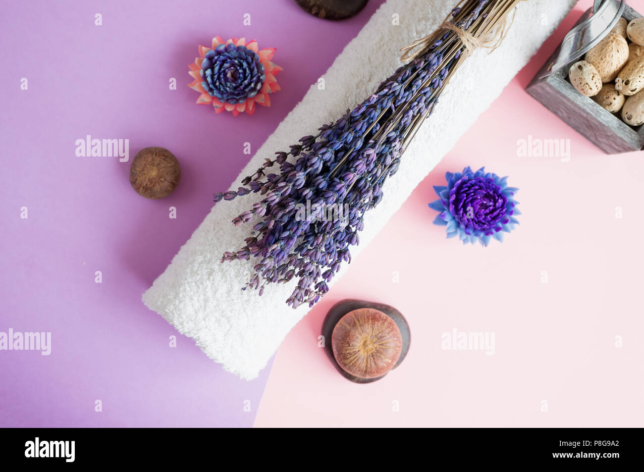 Beautiful soap in the form of flowers and towel with lavender flowers for Spa treatments on a two-tone background. Selective focus. Stock Photo