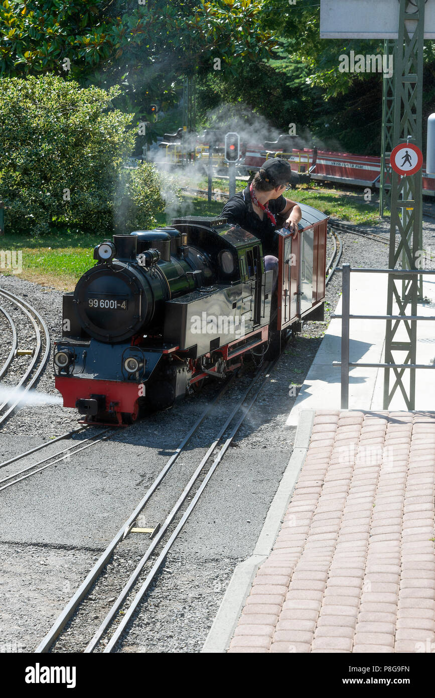 A Miniature Steam Railway Engine with Driver on Track at the Swiss Vapeur Parc by Lake Geneva Le Bouveret Switzerland Stock Photo