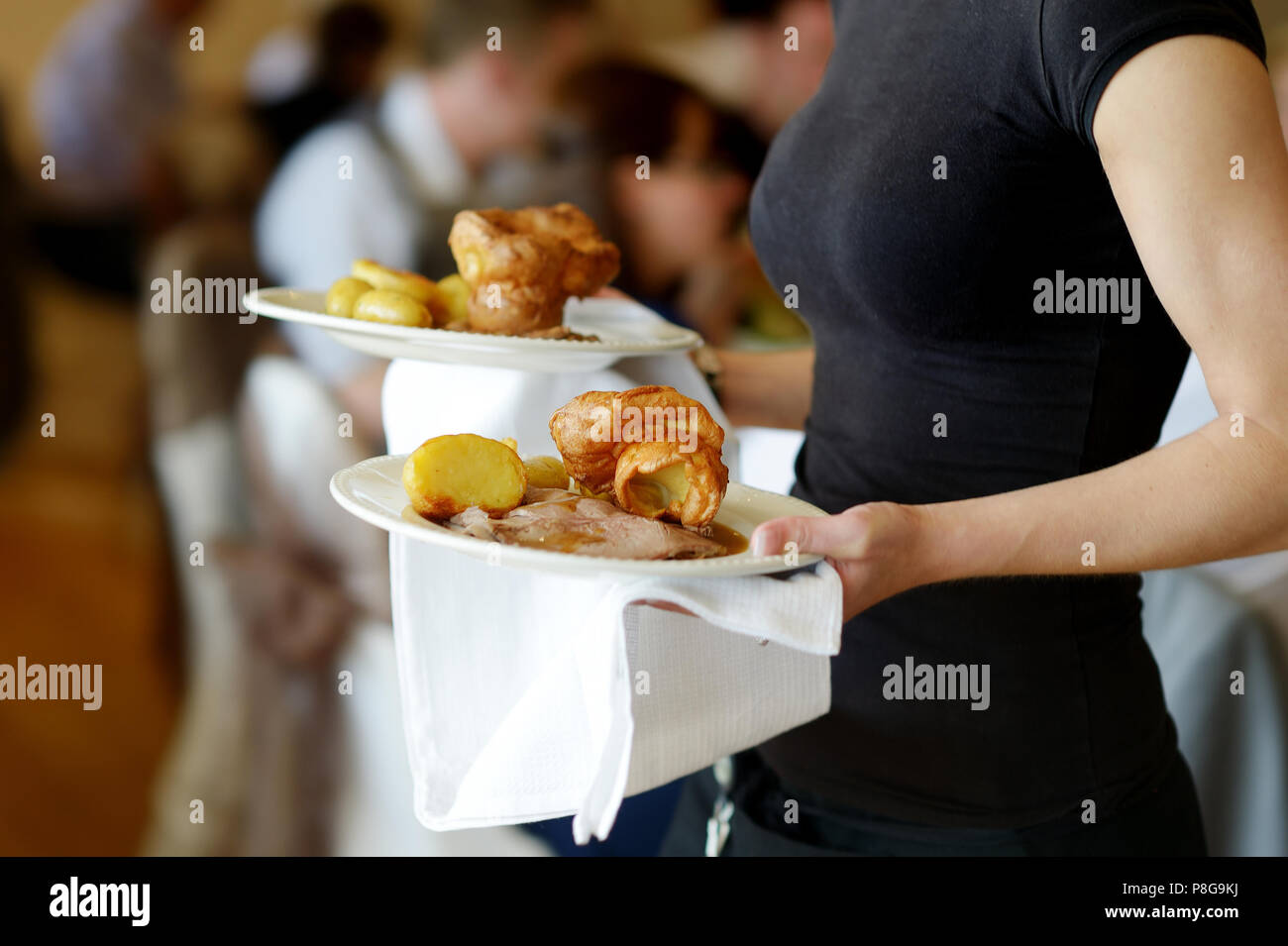 Waitress is carrying two plates with meat dish Stock Photo Alamy