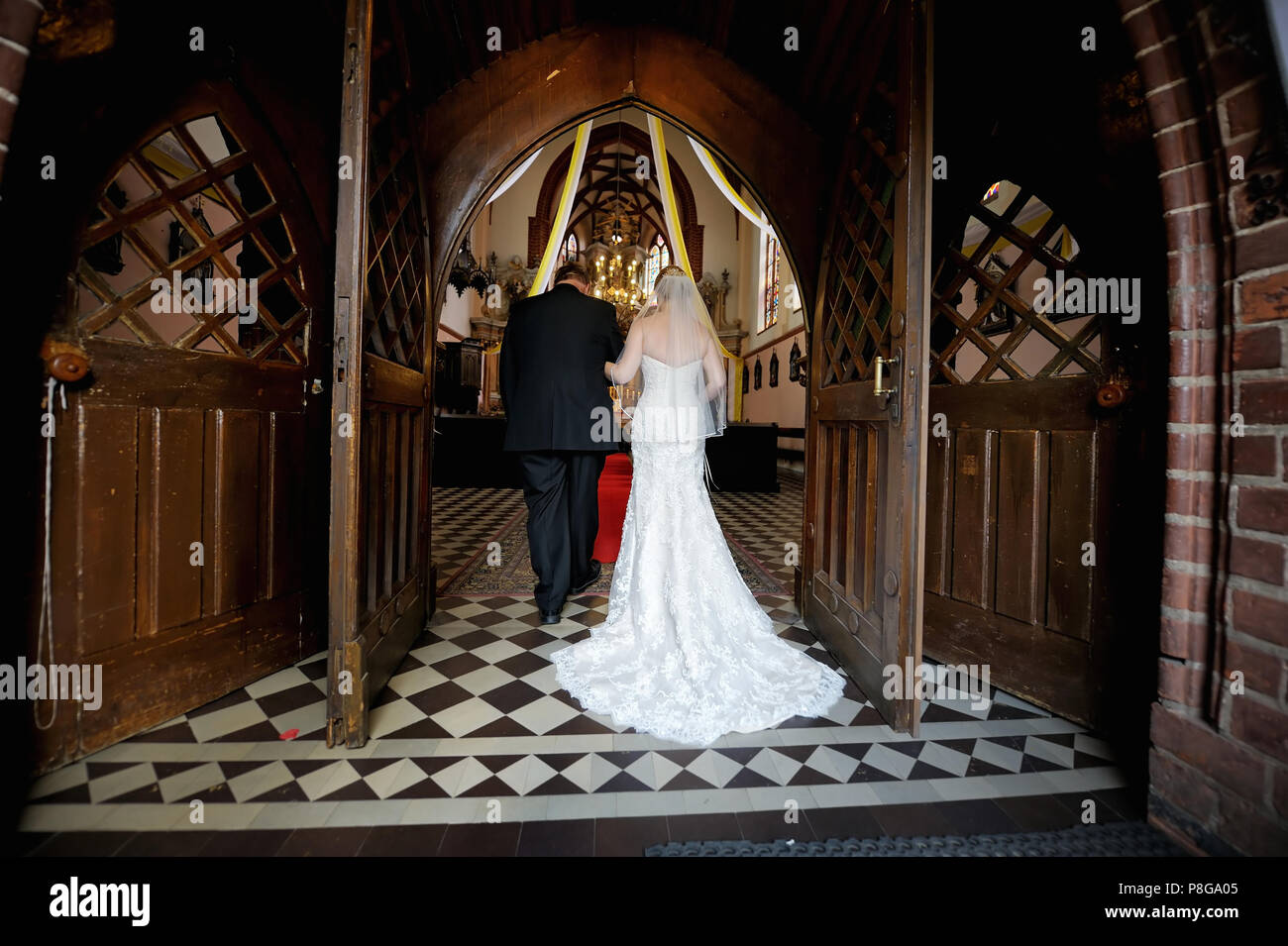 Bride walking down aisle with her father Stock Photo