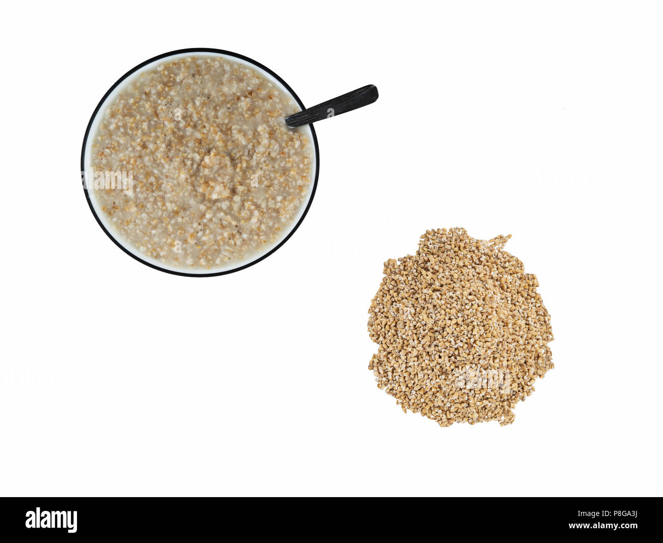Top view of cooked steel cut oats in bowl next to pile of raw steel cut